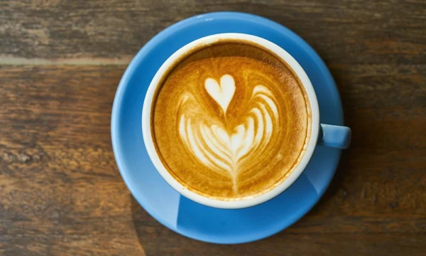 A cup of coffee with heart shaped latte art.