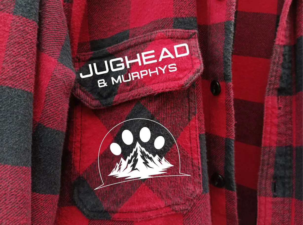 A close up of the pocket on a red and black plaid shirt.